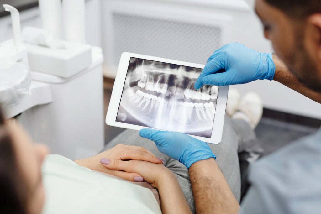 Stomatolog pokazuje pacjentowi zdjęcie zębów